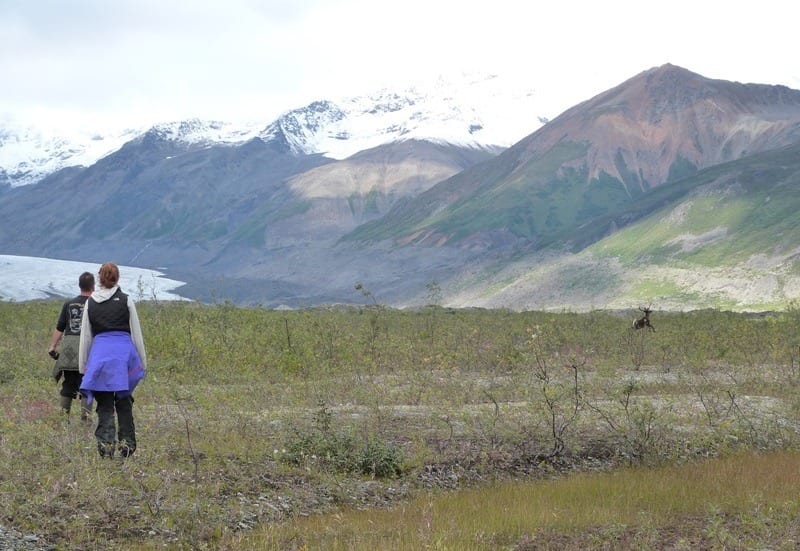 people hiking on a trail near mountains