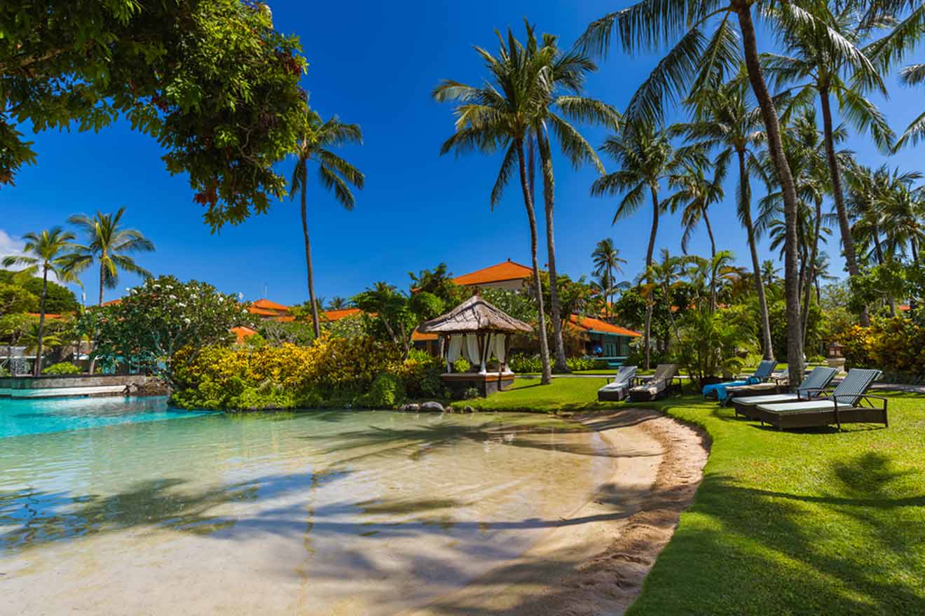 A pool with lounge chairs and palm trees