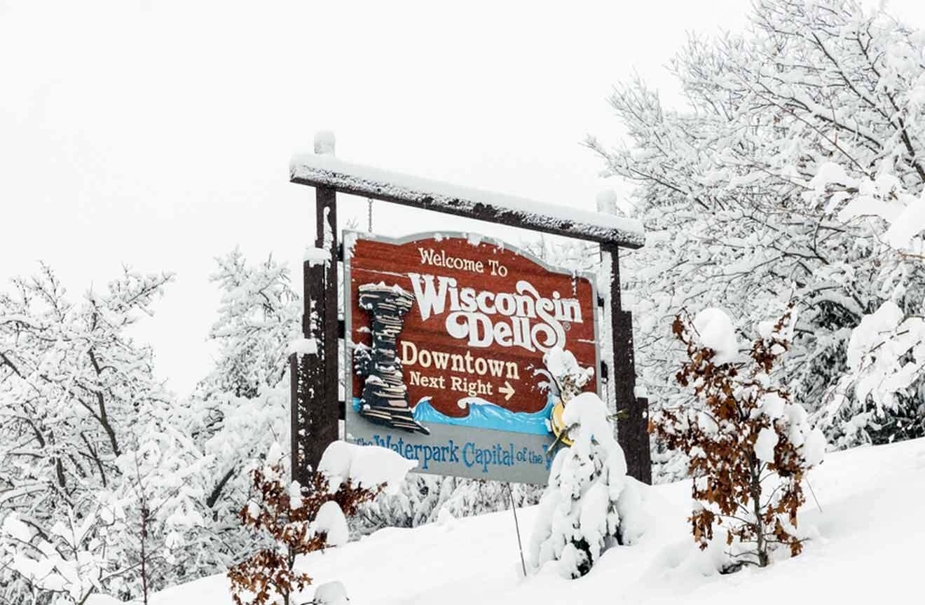 A sign in the snow with trees in the background.