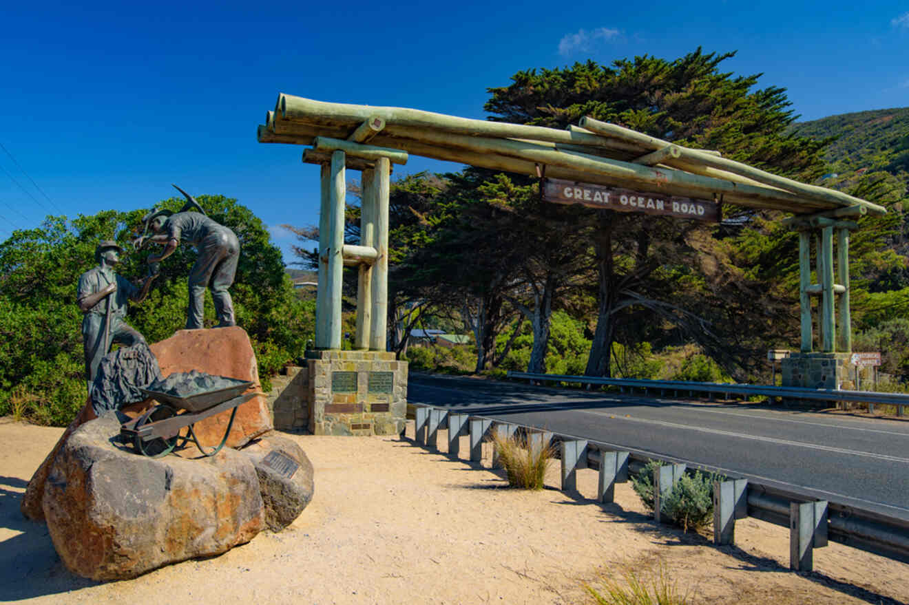 The entrance to a road with statues and rocks