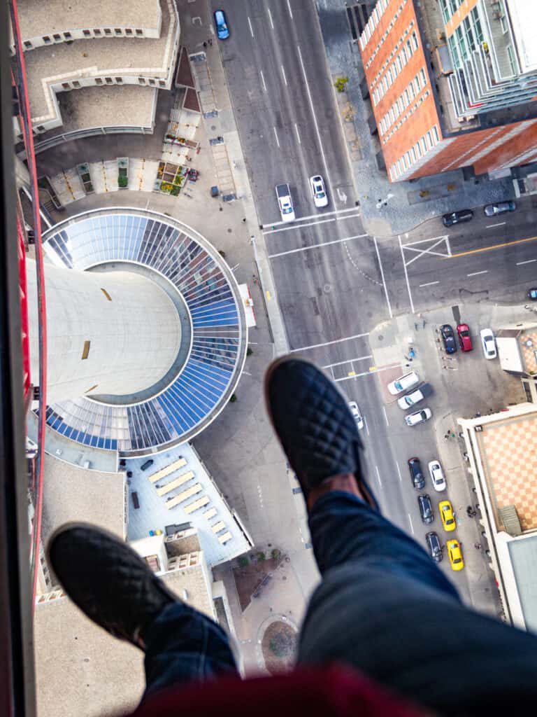 feet on glass floor with traffic underneath