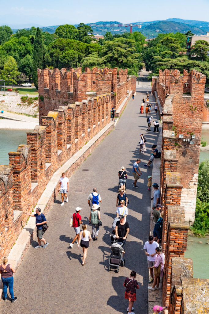 people walking across castelvecchio bridge