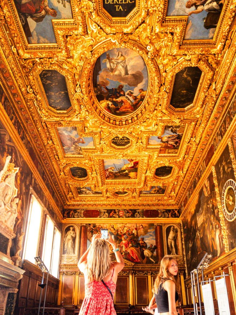 woman taking photograph of grand hall roof in doges