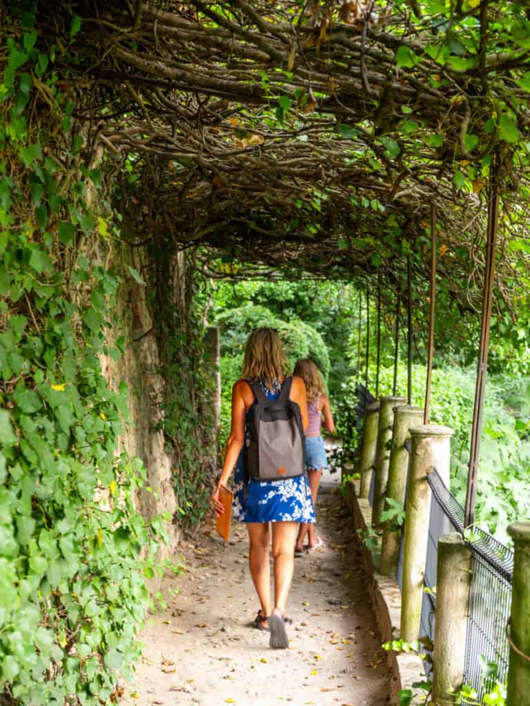 caz and girls walking through tunnel of plants