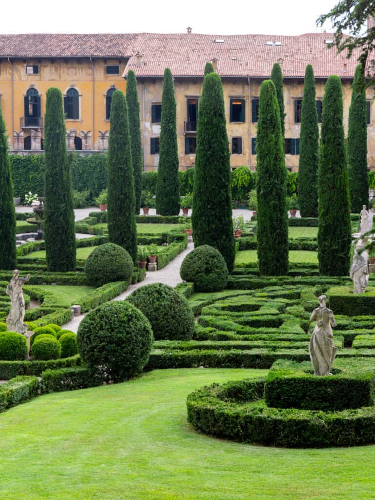 landscaped gardens, cypress avenue trees and hedges in front of villa