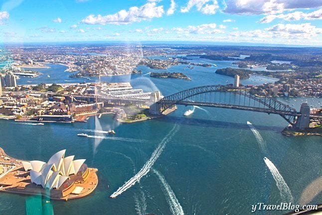 boats on sydney harbour with view of opera house and harbour bridge