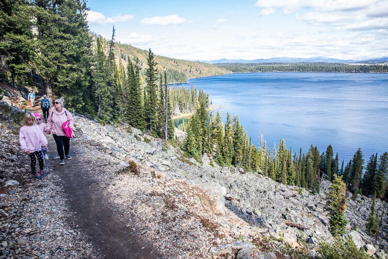 people walking on trail with Jenny Lake, in background