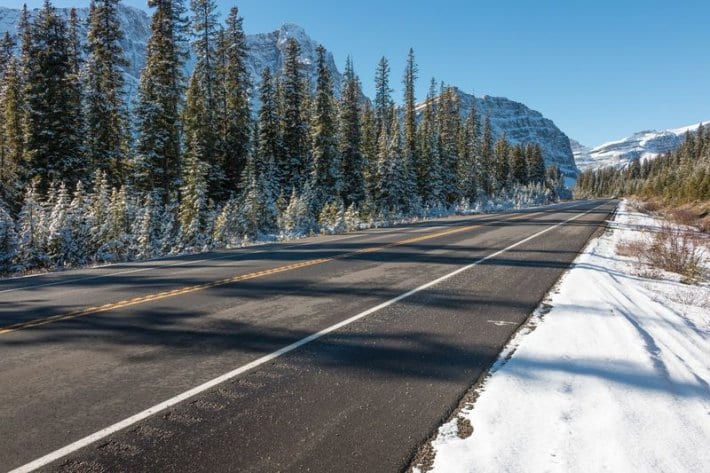 road running through snow valley