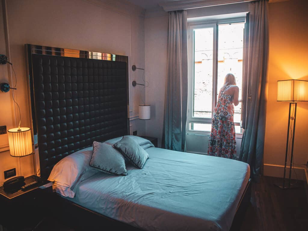 caz looking out window in apartment bedroom