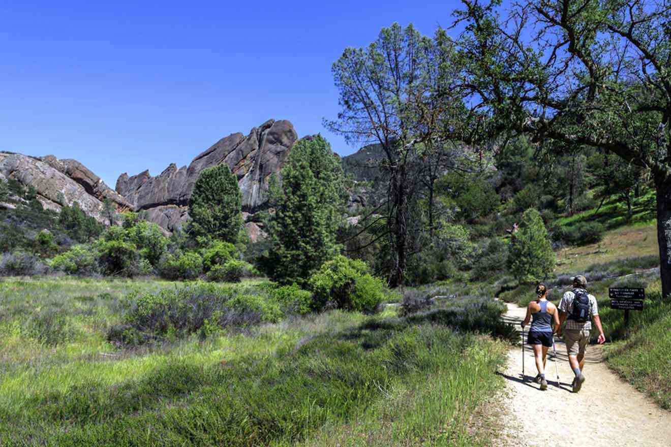 Two people hiking on a trail in the mountains.