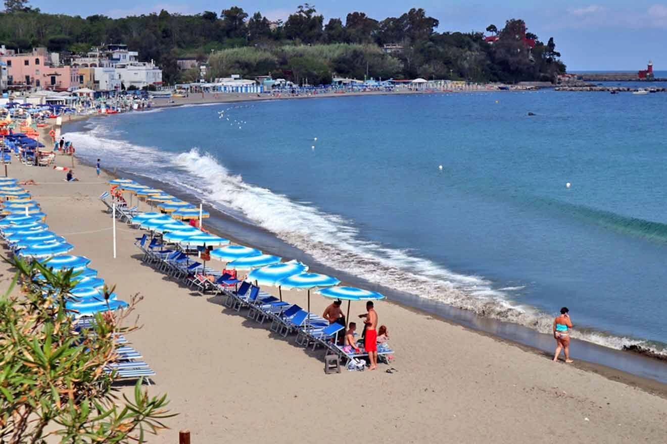 A beach with umbrellas and chairs along the shore.