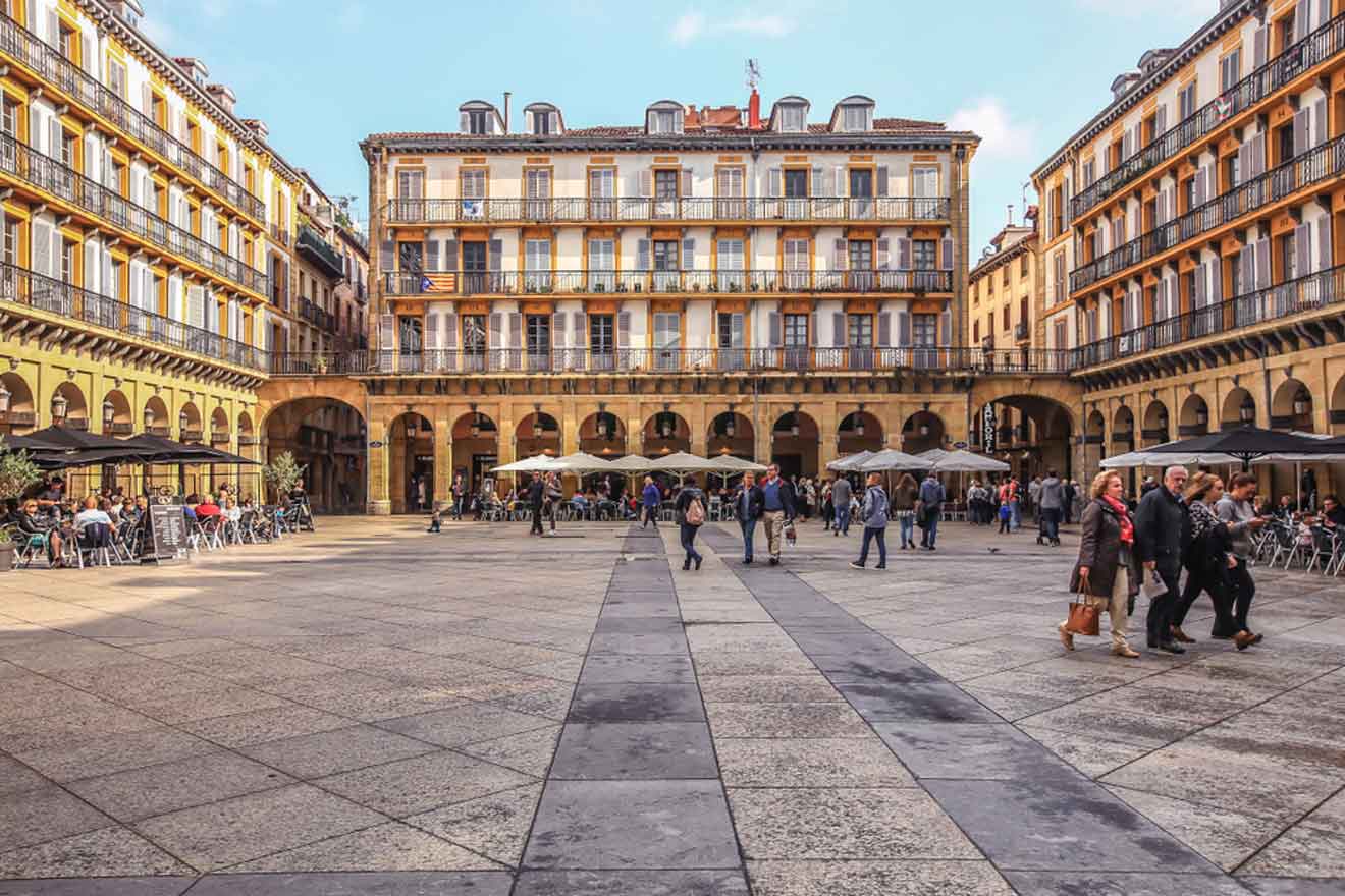 A square in a city with people walking around.