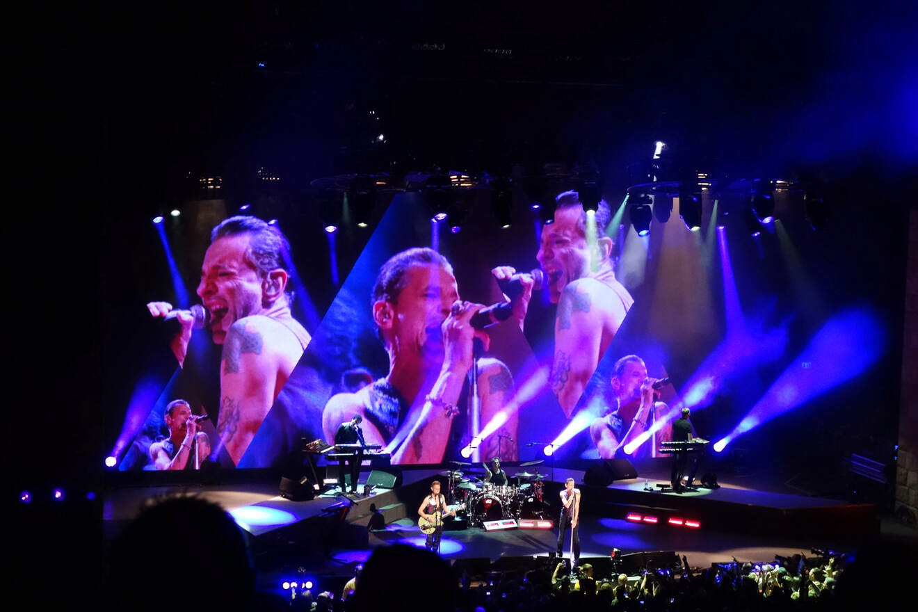 A group of people on stage in front of a large screen.