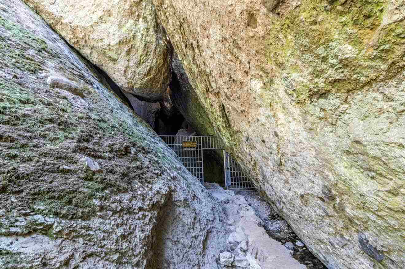 The entrance to a cave with a metal gate.