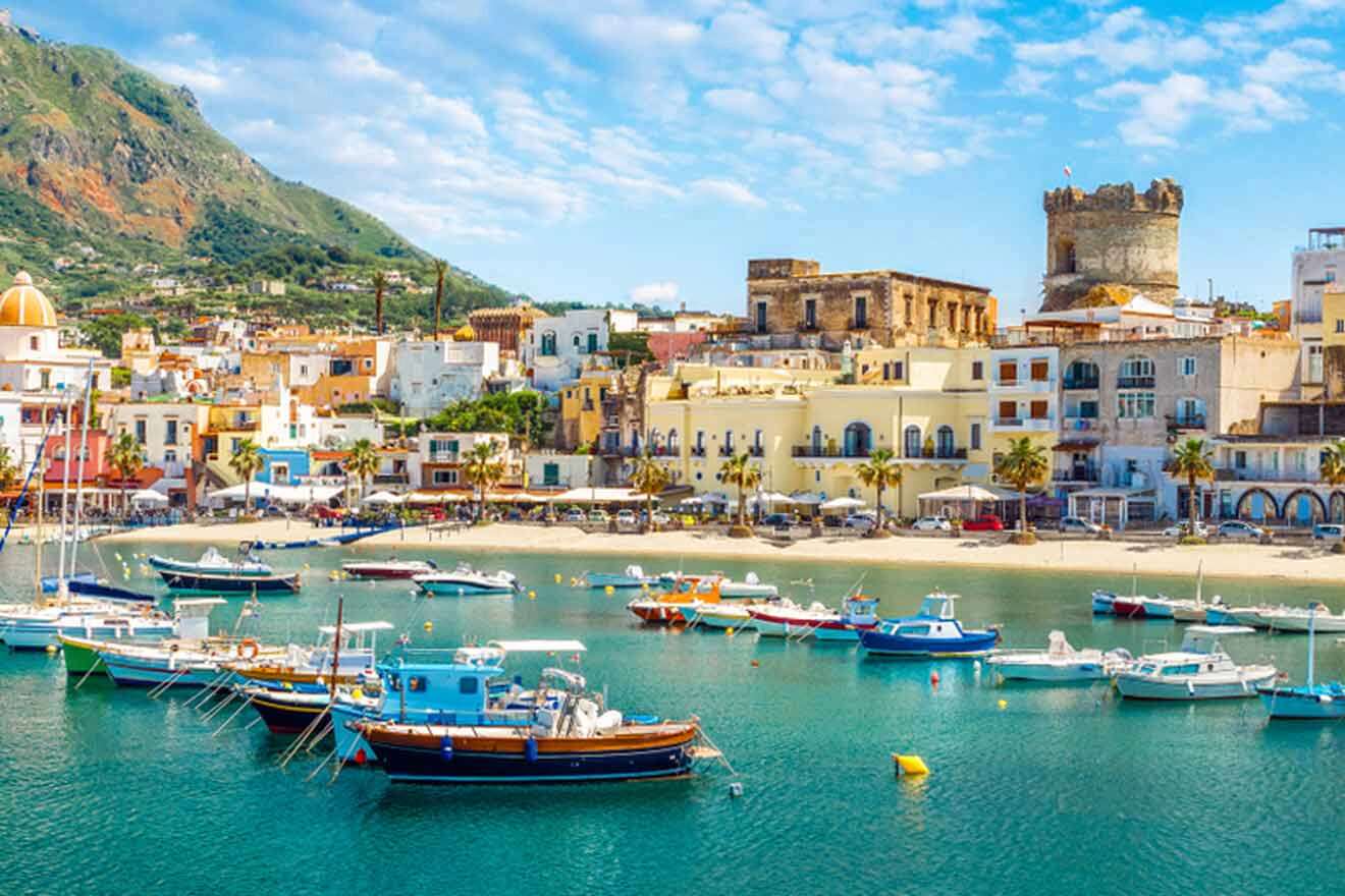 A town with boats docked in the water and a mountain in the background.