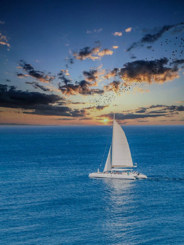 catamaran on sea with sunset