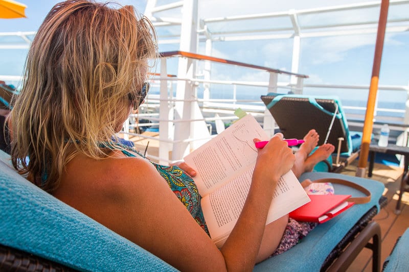 caz reading a book on lounge chair by pool