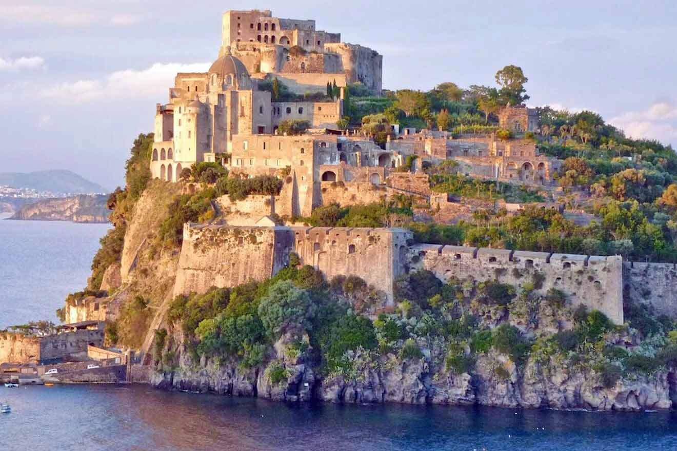 A castle sits on top of an island in the ocean.