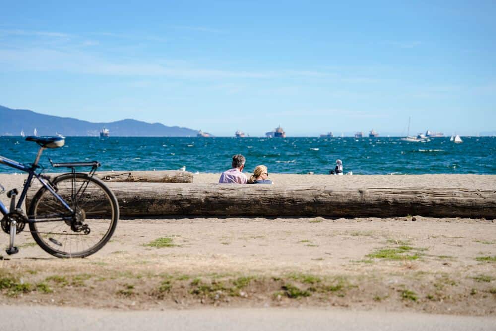 peopel sitting on English Bay Beach Vancouver