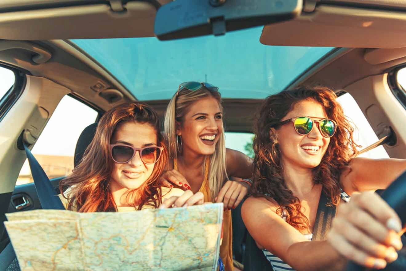 Three women in a car looking at a map.