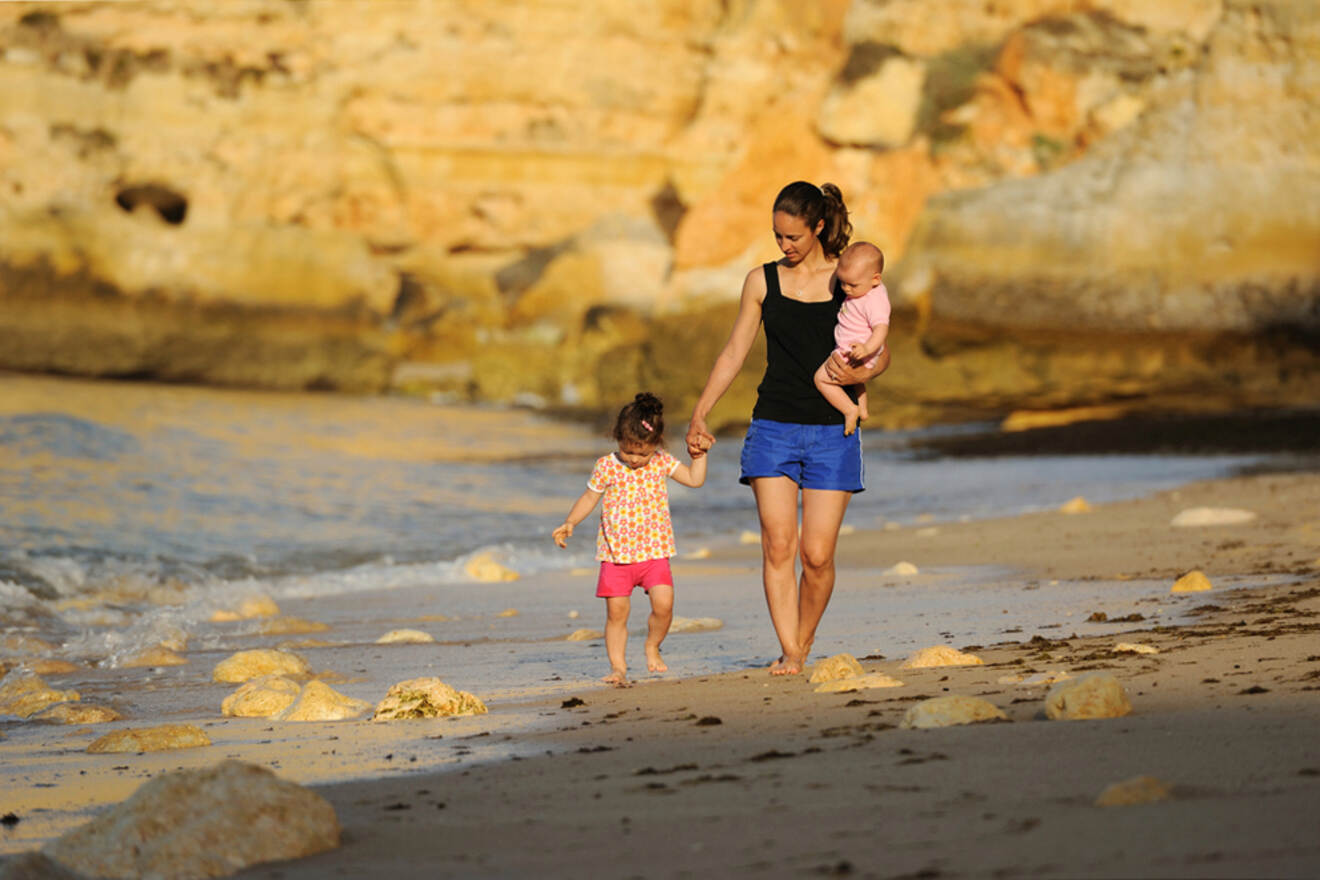 mom with her kids walking on a beach