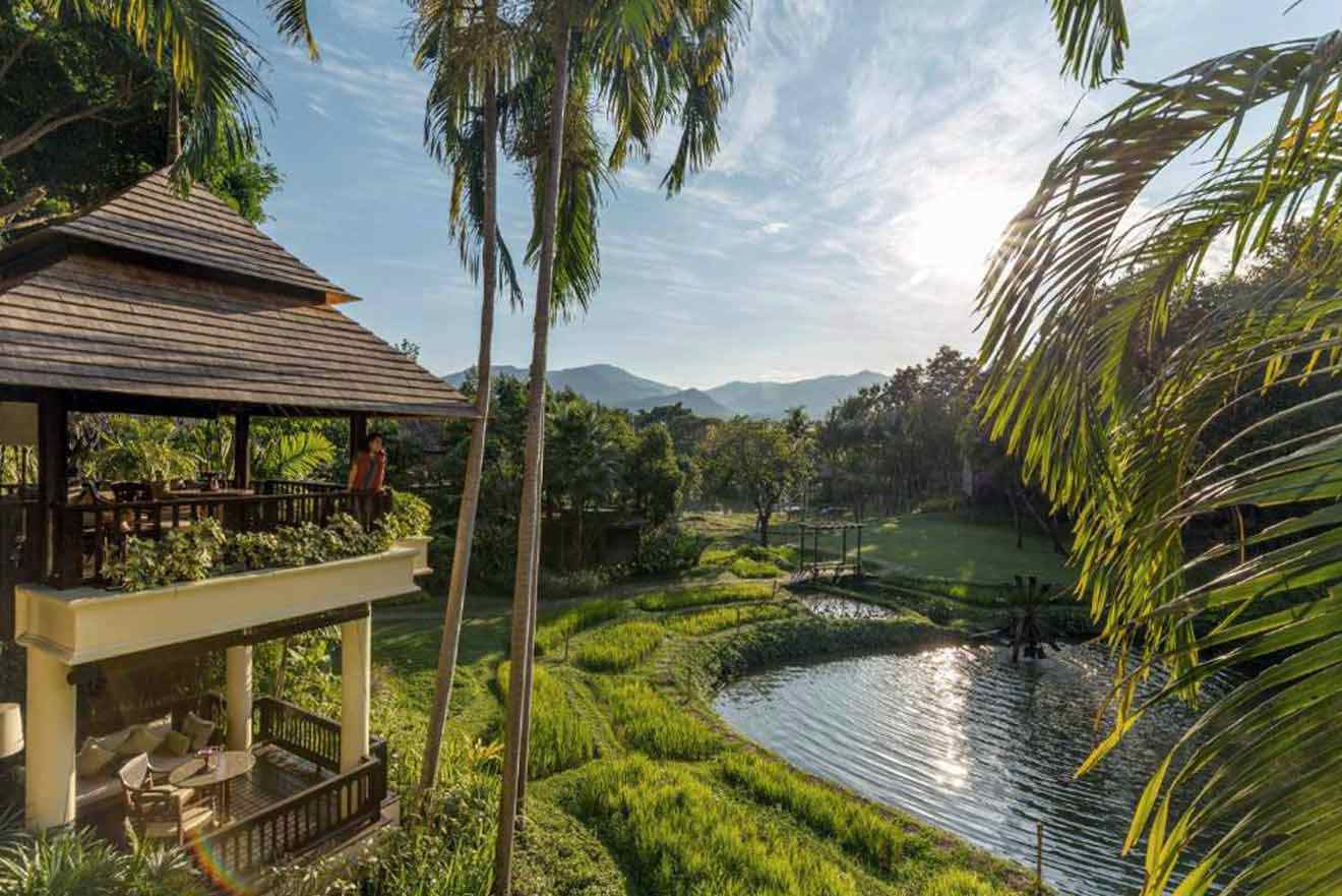 A view of a resort with a pond and palm trees.