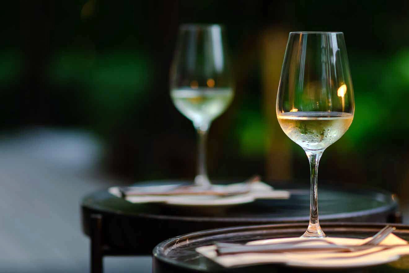 glass of wine on a table next to cutlery