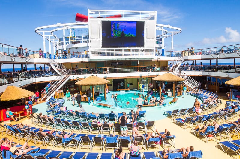 people swimming in pool and enjoying deck of carnival cruise