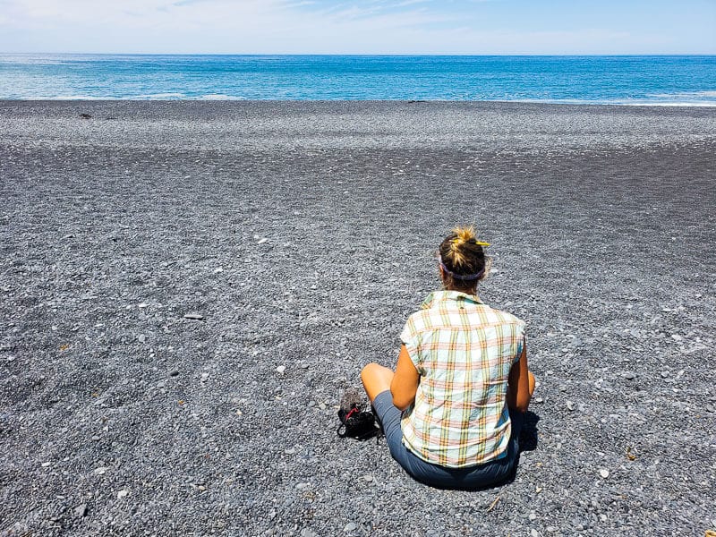 caz sitting on black sand beach lost coast road trip (1)