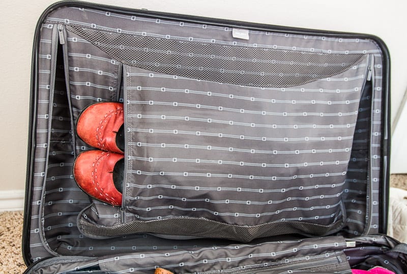 shoes inside zipper section of suitcase