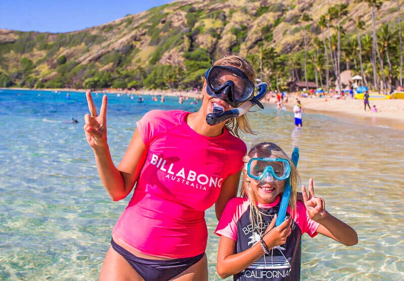 mother and daughter wearing snorkel gear posing at camera