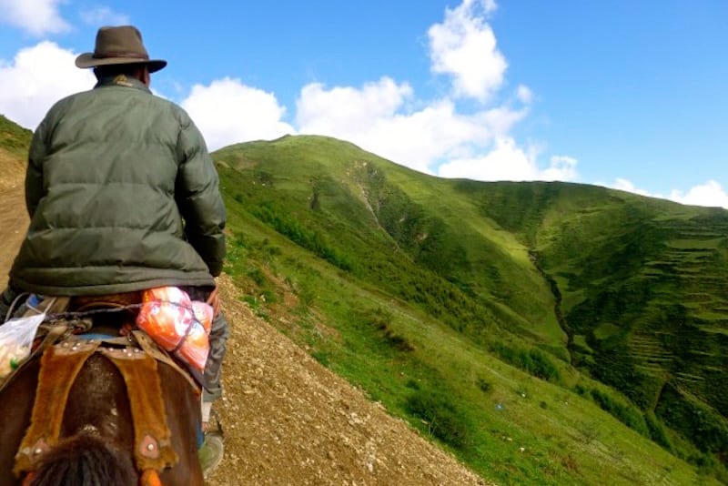 man riding horse in mountains 