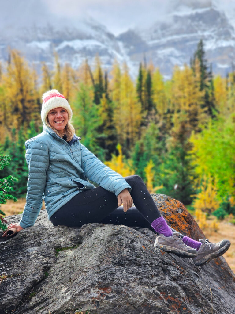 caz smiling at camera surrounded by fall foliage forest