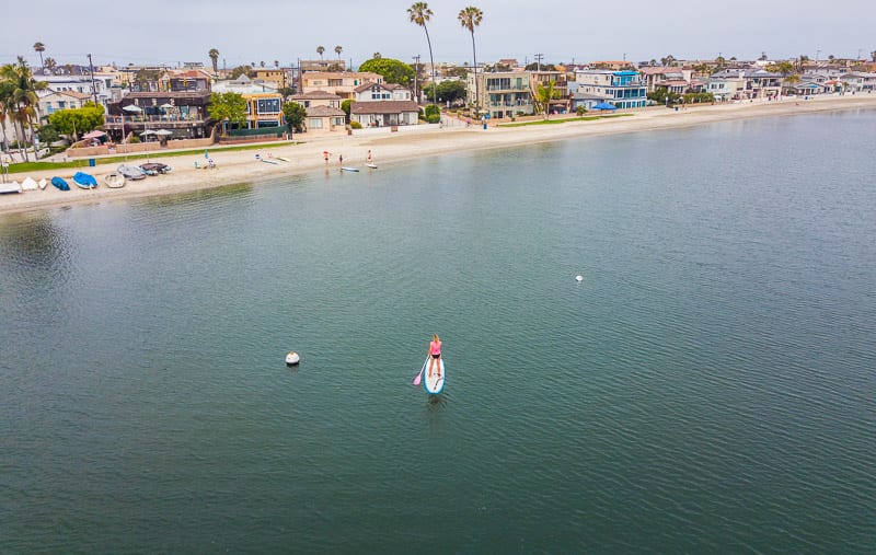 woman paddle boarding on lagoon