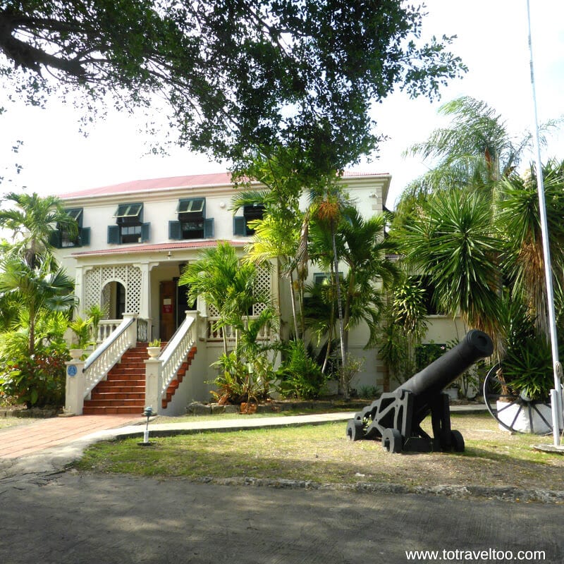 cannon sitting on lawn outside white Sunbury Plantation House