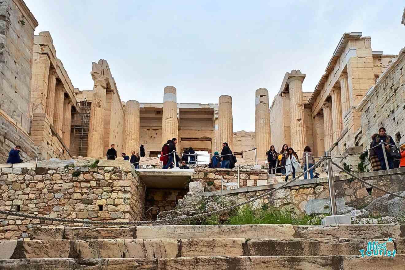 A group of people standing on the steps of an ancient building.