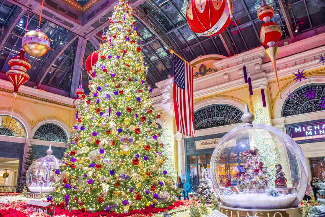 a giant Christmas tree and snow globe in a hotel's lobby