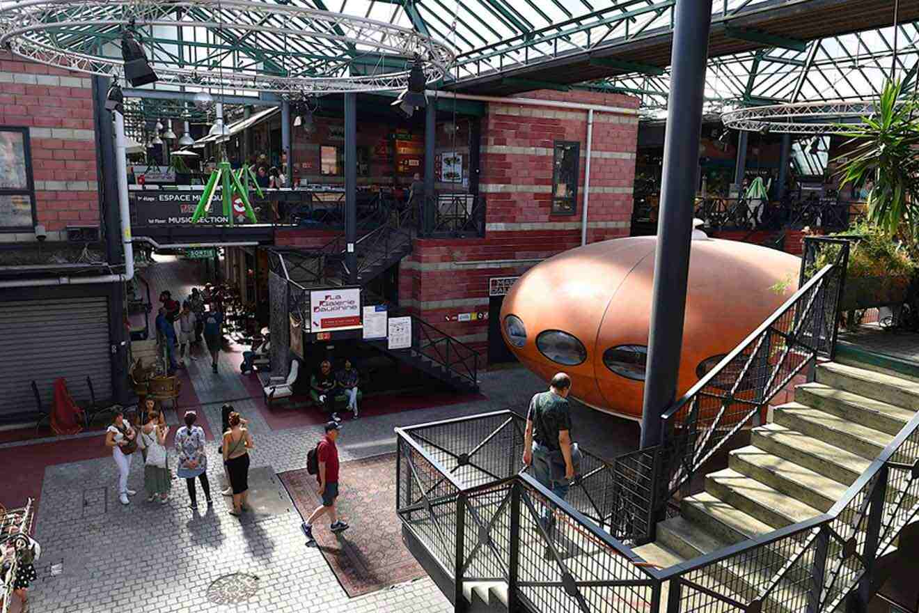 A group of people walking through a building with a large orange object.