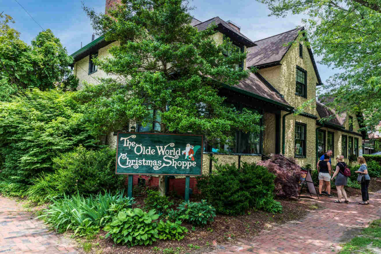 A group of people walk past a house with a sign that says the old world christmas shop.