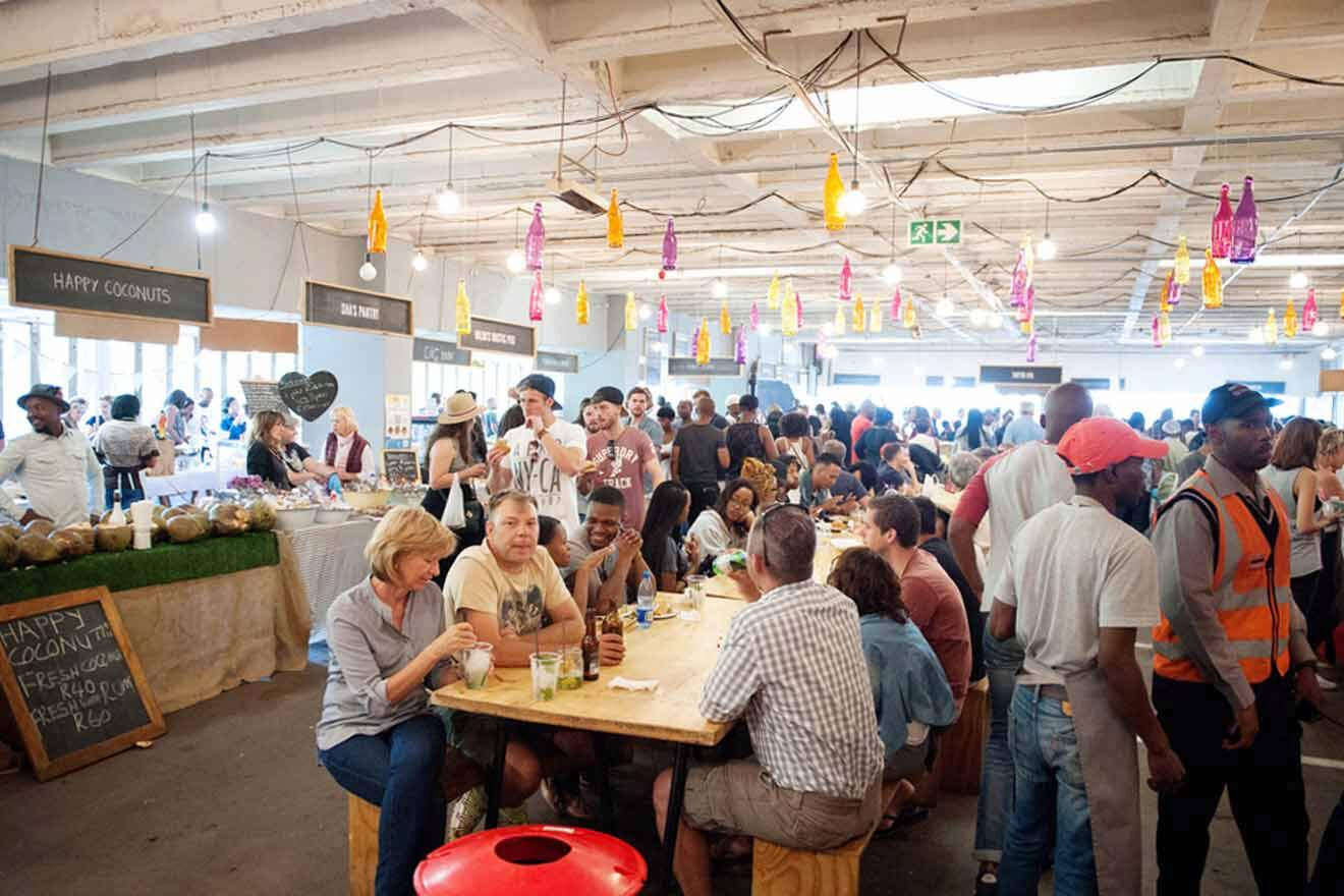 A crowd of people sitting at tables in a warehouse.