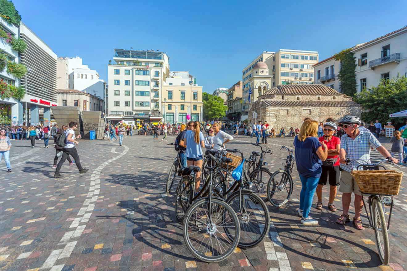 A group of people standing in a square with bicycles.