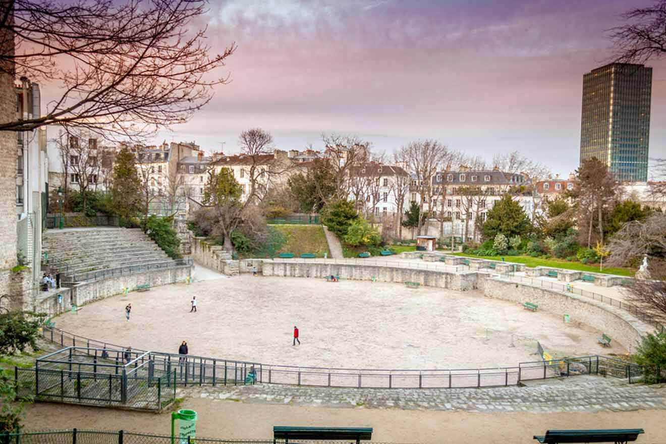 A park with benches and a playground in the background.