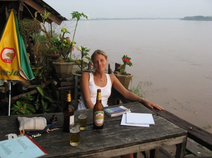 a woman sitting on a table next to water