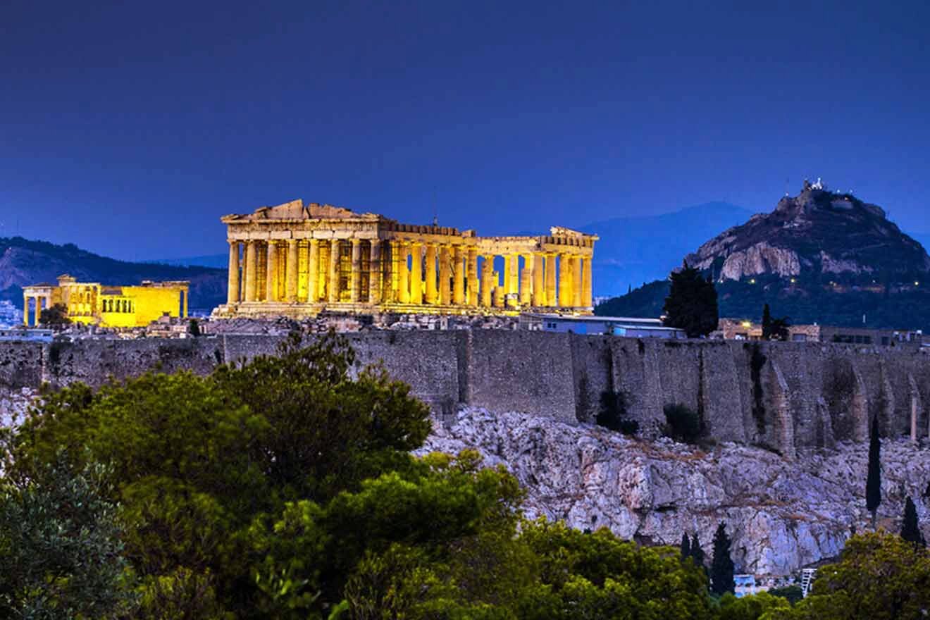 The parthenon is lit up at night.