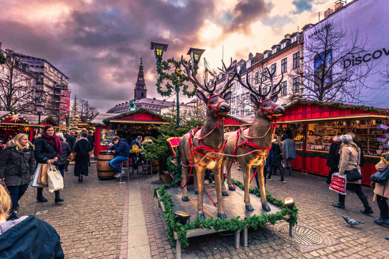 A statue of reindeer and wooden stalls behind them