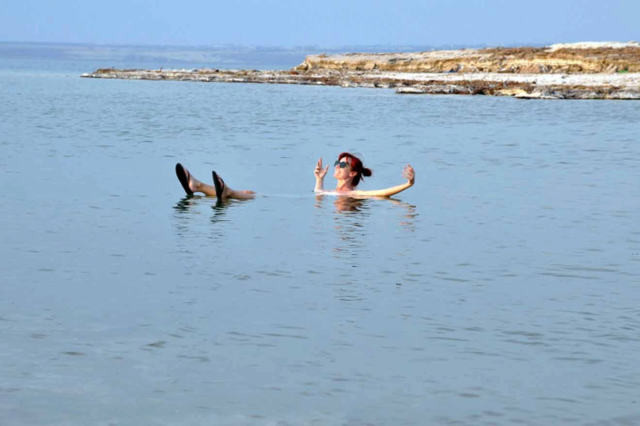 A woman floating in the water with her arms outstretched.