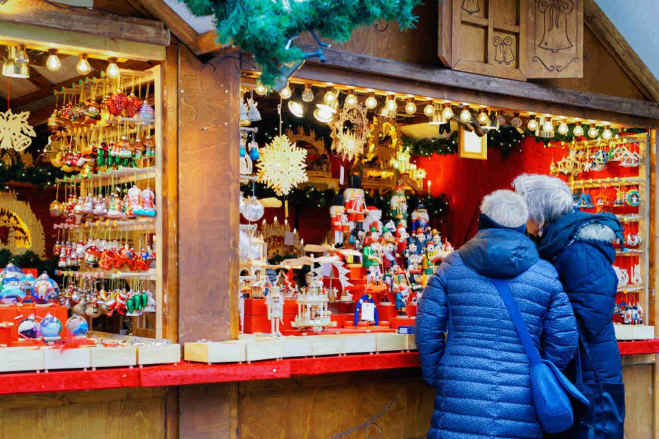 People looking at Christmas decorations on a wooden stall