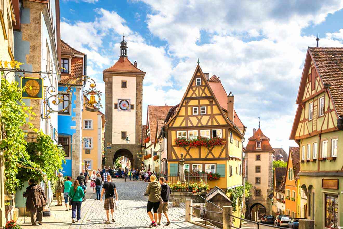 People walking down a cobblestone street in germany.