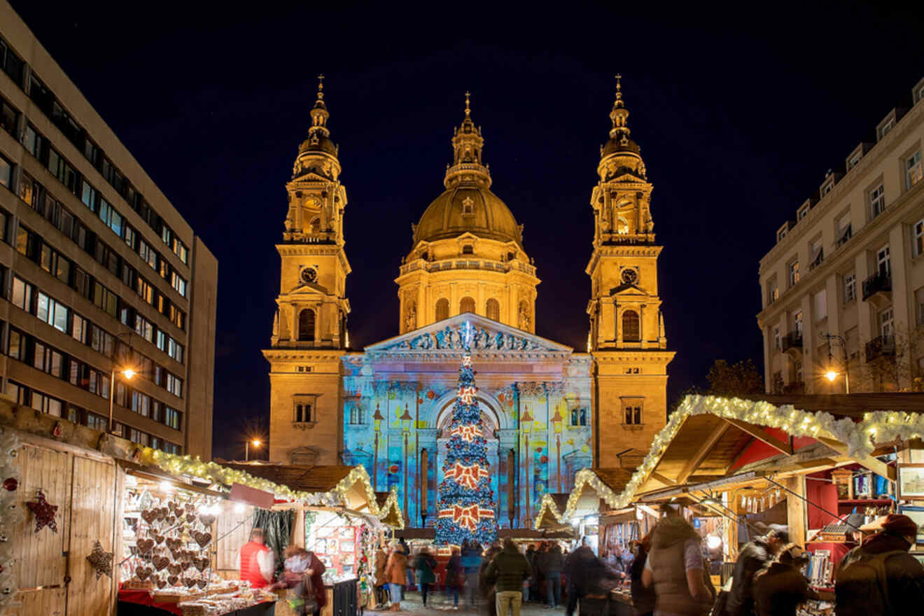 Christmas projections on a cathedral with a tree and wooden stalls in front of it