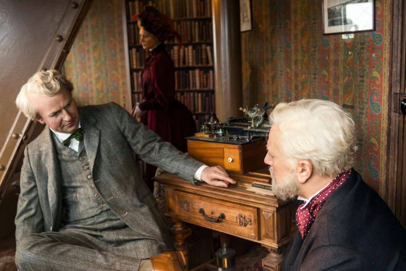 Two men sitting in a room with a record player.